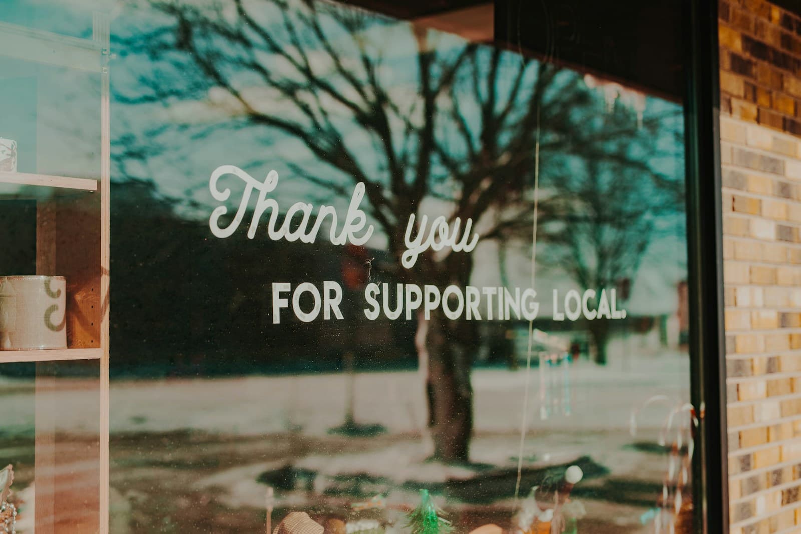 “Thank you for supporting local” painted on a shop window